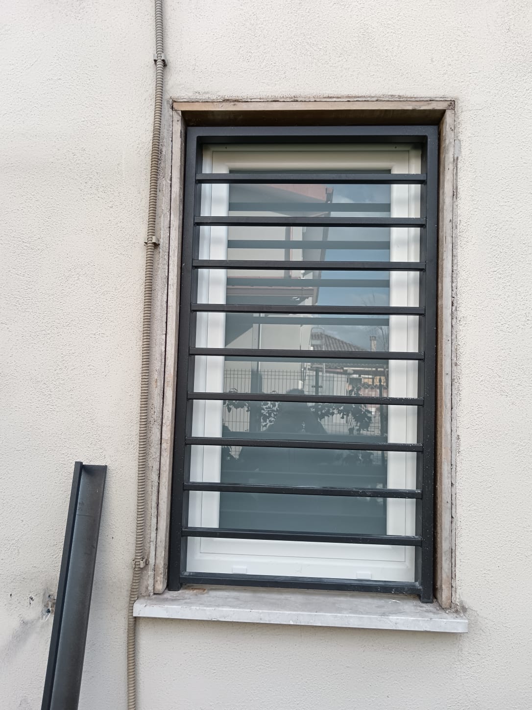 Grata di sicurezza in ferro nera installata su una finestra, vista dalla facciata